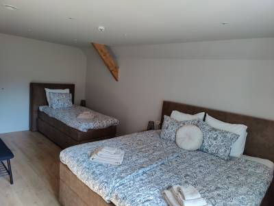 Vernieuwde kamer 6 met dubbel bed, enkel  bed en open kast.