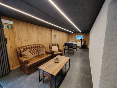 Vernieuwde kelder met chesterfield zetels, voetbaltafel, loopband en hometrainer, infraroodsauna, toppenbiljarttafel, bar en darts.