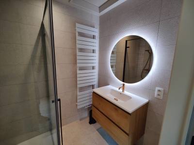 Salle de bain à l'étage avec douche à effet pluie spacieuse, placard, grand miroir et sèche-serviettes.