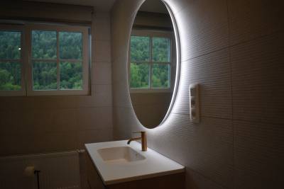 Salle de bain spacieuse avec miroir éclairé et vue sur la vallée.