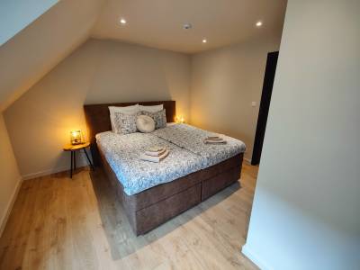 Lit fait avec un beau sol en carrelage parquet.