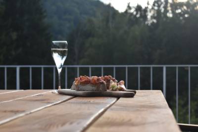 Les tables de jardin en bois sur la terrasse offrent une vue sur la vallée avec une délicieuse collation et une boisson.